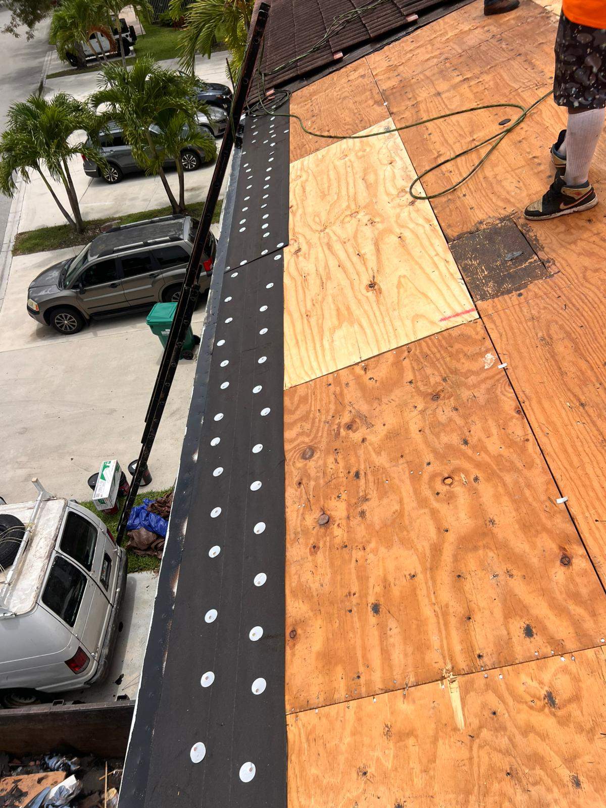 Emergency roofing services crew securing a tarp over storm damage on a Palm Beach Gardens home